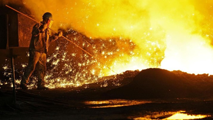 An employee works next to molten iron at a steel mill of Dongbei Special Steel in Dalian, Liaoning province, China July 17, 2018. REUTERS/Stringer ATTENTION EDITORS - THIS IMAGE WAS PROVIDED BY A THIRD PARTY. CHINA OUT.