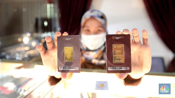 Petugas menunjukkan emas batangan di sebuah gerai emas di Pegadaian, Jakarta. (CNBC Indonesia/Muhammad Sabki)
