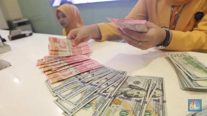 Ilustrasi Rupiah dan Dollar di teller Bank Mandiri, Jakarta, Senin (07/5). Nilai tukar rupiah terhadap dolar Amerika Serikat (AS) masih melemah. Rupiah melemah 0,32 % dibandingkan penutupan akhir pekan lalu. Harga jual dolar AS di bank Mandiri Rp. 14.043. (CNBC Indonesia/Muhammad Sabki)