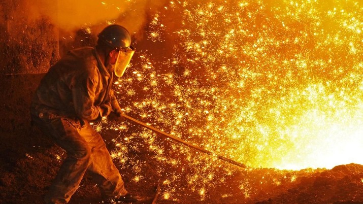 An employee works next to molten iron at a steel mill of Dongbei Special Steel in Dalian, Liaoning province, China July 17, 2018. REUTERS/Stringer ATTENTION EDITORS - THIS IMAGE WAS PROVIDED BY A THIRD PARTY. CHINA OUT.