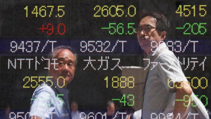 Passersby are reflected on a stock quotation board outside a brokerage in Tokyo, Japan, August 6, 2019. REUTERS/Issei Kato
